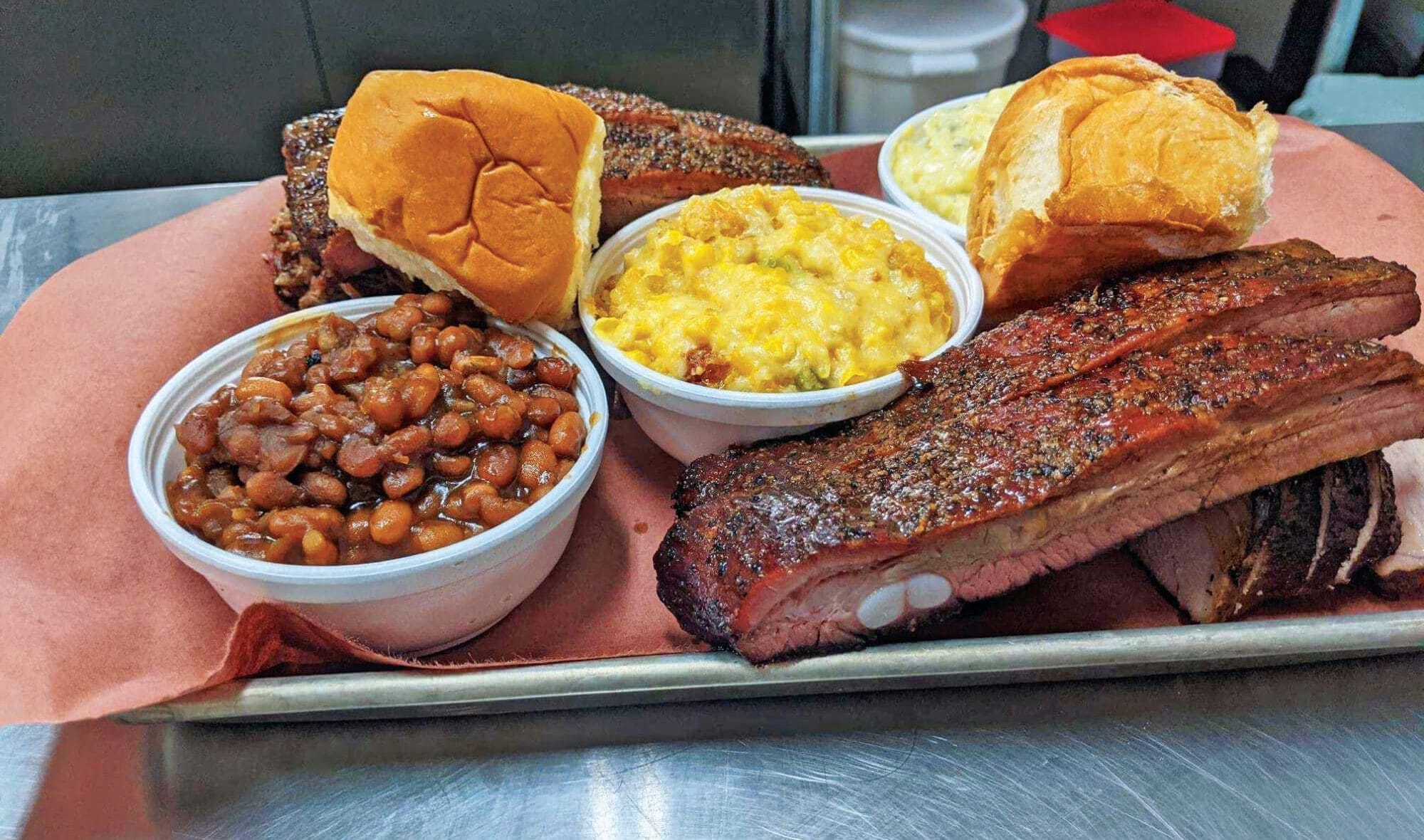 A platter of spare ribs, chopped brisket, beans, and jalapeno corn casserole at Kane Street Smokehouse in Gate City.